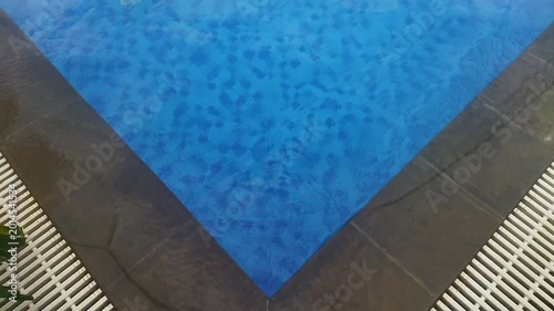 Entering a clear blue pool from a stone pool deck
