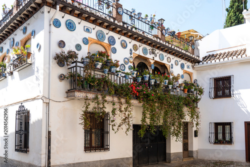 traditional Andalusian house decorated with ceramic plates and flowers in the historic Albayzín neighborhood of Granada, Spain