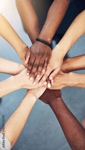Group of diverse hands joined in a communal stack, emphasizing unity and teamwork