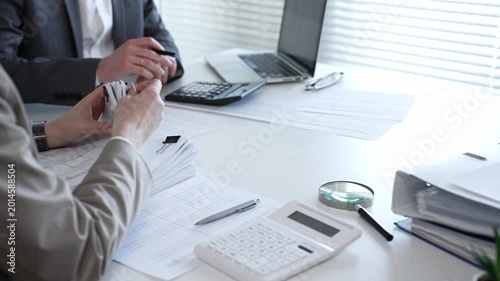 Business people reviewing financial documents, calculating tax, auditing corporate accounting records, and processing paperwork in office. Audit and taxes in business