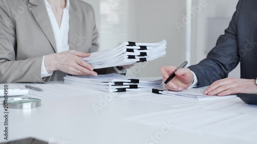 Business professionals analyzing documents and paperwork, calculating finances in an office environment. Audit and taxes in business