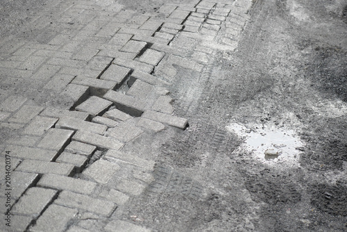 Cracks in pavement and puddle on a street