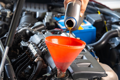 Refueling and pouring oil quality into the engine motor car Transmission and Maintenance Gear .Energy fuel concept.	