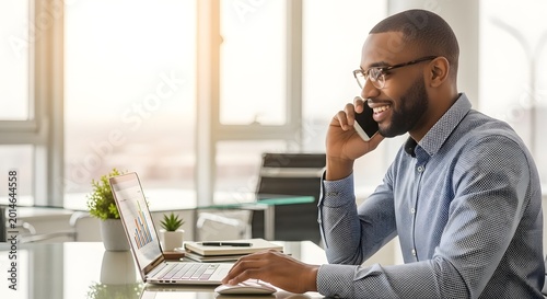 Smiling Businessman on Laptop Talking by Window Light
