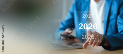 Businessman vision for 2026 with digital interface of years for future success and growth strategy planning.