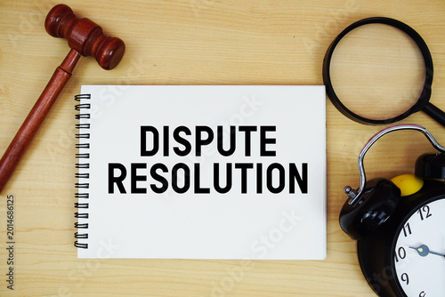 Fotografie Dispute Resolution text written on notepad with pen, alarm clock and judge gavel