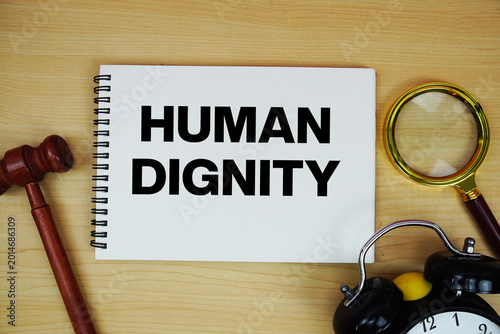 Foto Human Dignity text written on notepad with pen, alarm clock and judge gavel on w