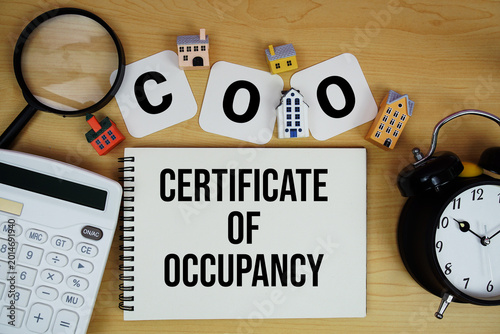 Bild auf Leinwand COO Certificate of Occupancy text written on notepad with house model, alarm clo