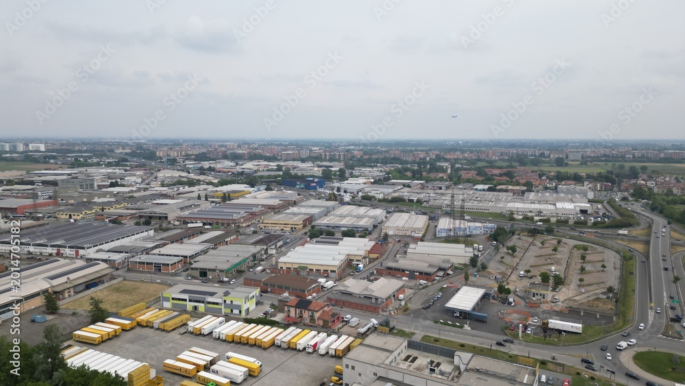 Fototapeta premium Industrial Cityscape: An expansive view showcases the vibrant heart of industry and commerce, featuring an intricate network of warehouses, San Giuliano Milanese, Milan, Italy, 