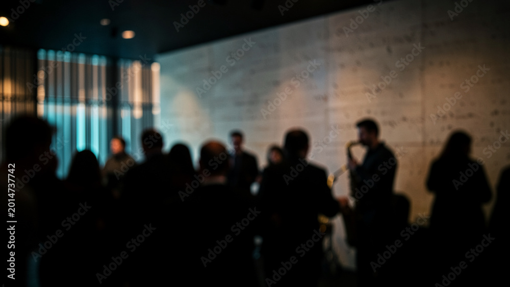 Fototapeta premium Concert audience silhouettes watching a live performance in a dark venue