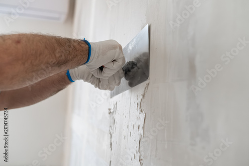 Obraz na płótnie A professional contractor smoothing plaster on a wall using a stainless steel trowel