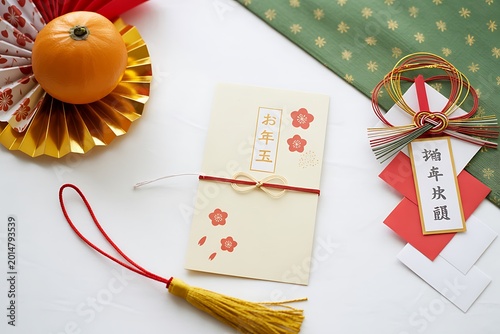 Japanese new year decorations including otoshidama envelope and mandarin orange