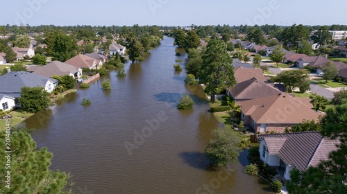 Aerial view of a flooded suburban residential neighborhood with houses surrounded by deep water after a natural disaster.