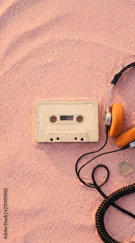 Nostalgic still life captures a vintage cassette tape paired with modern headphones. The arrangement evokes a sense of retro coolness and auditory enjoyment.