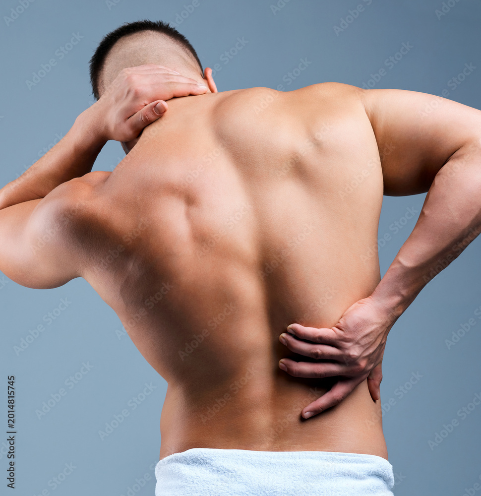 Fototapeta premium Neck pain, back and man with sore muscle, health problem or workout strain on gray background. Spine, injury and male with stress or tension with body ache, bad training or exercise inflammation