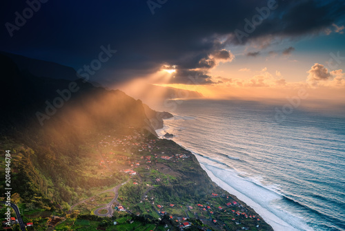 Dramatic Landscape of Madeira Island with Golden Sun Rays Piercing through Clouds over the Atlantic