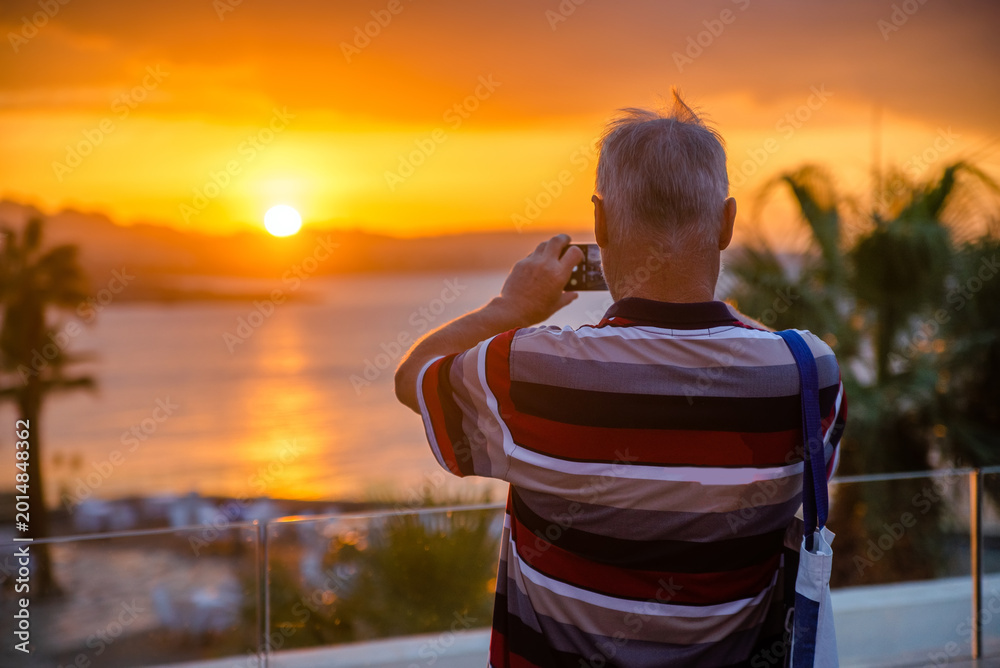 Fototapeta premium A man takes pictures of the sunset over the Red Sea 