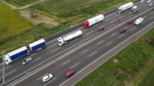 Highway Haulage: A bird's-eye perspective captures a multi-lane highway bustling with the constant flow of traffic. The image shows variety of trucks, cars on a busy road.