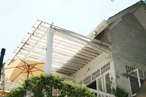A charming outdoor dining area with white pillars and a canopy