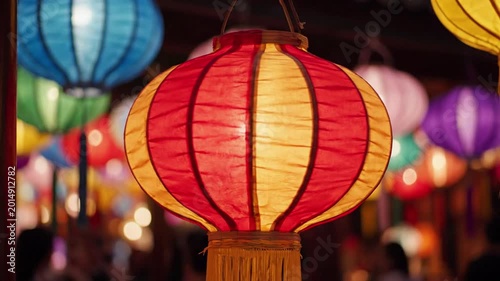 Traditional Chinese red and yellow paper lantern glowing brightly at night, surrounded by other colorful festive lanterns, cultural celebration atmosphere