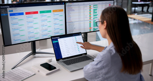 Fotografi Woman Uses Multiple Screens Analyzing Supplier Data