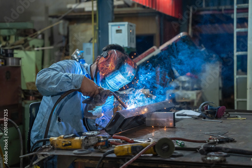 Foto Welding sparks fly metal fabrication workshop industrial setting action shot clo