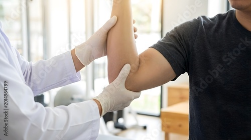 Doctor checking patient's elbow, physical therapy for arm injury recovery.