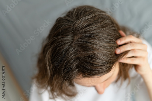 Fotografi A woman faces decision of whether to dye her graying hair or let it be natural