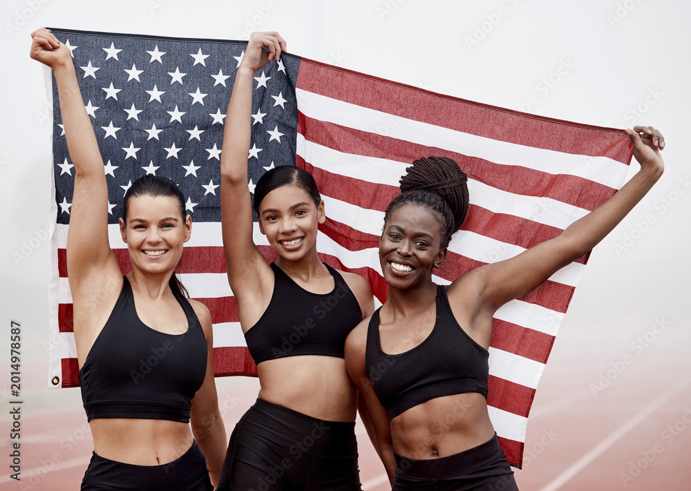 Fototapeta premium Winner, team and portrait of women with USA flag for winning marathon, competition and track event. Stadium, sports and people with banner to celebrate achievement, race champion and runner challenge