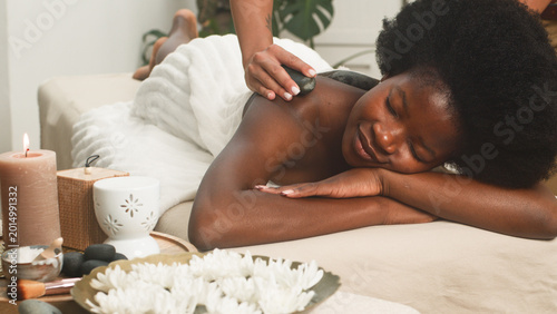 Relaxing Hot Stone Back Massage For Woman At Serene Spa With Candles And Flowers