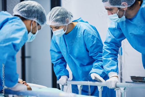 Konstfotografi Medical professionals in surgical scrubs and protective gear attending to a pati