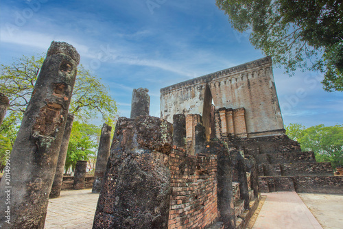 Ancient stone pillars ,columns at Sukhothai province Thailand, stand tall against a clear blue sky. Weathered columns exhibit showcasing historical architecture.