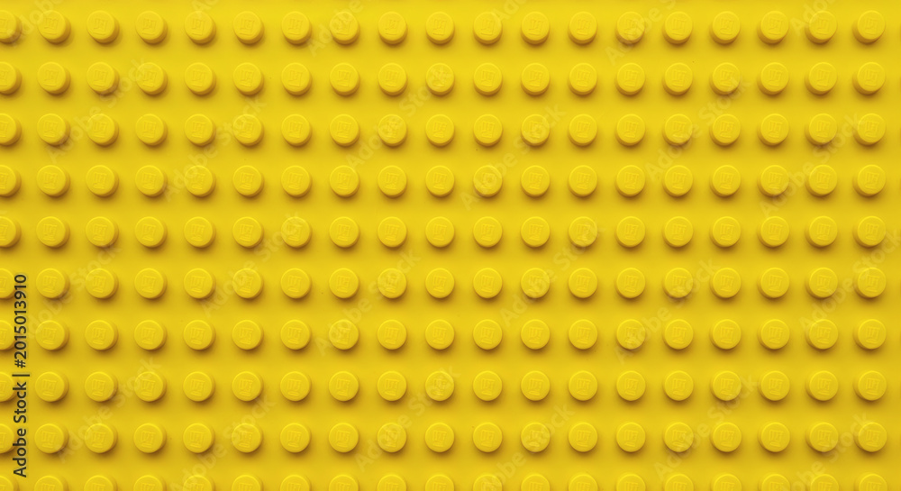 Fototapeta premium Yellow plastic building block plate texture background for kids toys