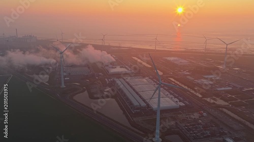 Google data center with wind turbines producing renewable energy at sunrise