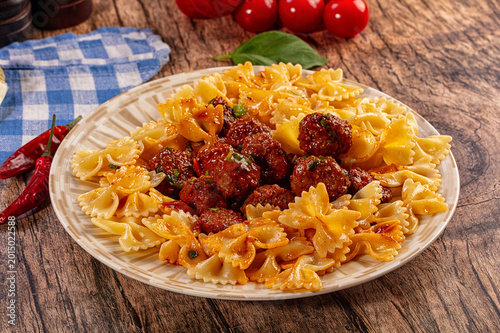 Εκτύπωση καμβά Delicious farfalle pasta with meatballs and tomato sauce on a rustic wooden tabl