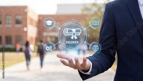Academic degree digital holographic concept held by professional on university campus showing graduation diploma knowledge skills and global education icons for higher learning achievement