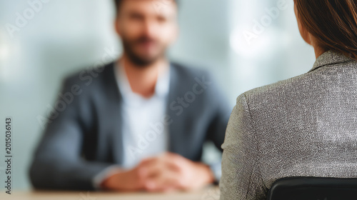 A professional setting showcasing a focused interview between a candidate and an interviewer, highlighting workplace dynamics.