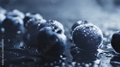 Fresh blueberries with water droplets on dark reflective surface, cinematic macro of chilled organic berries, cold blue moody food photography