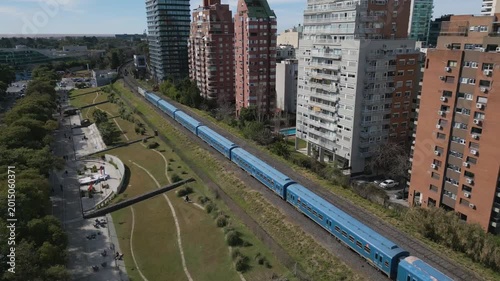 Train travels through urban area in Mexico City during sunny day