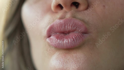 Lips mouth woman making pouting expressions and kissing gestures in an extreme close up shot with natural lighting
