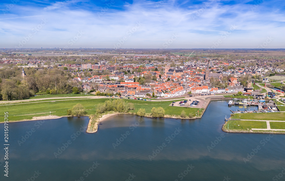 Obraz premium Aerial view of historic Wijk bij Duurstede with red roofs, Lek river, dyke road and harbor with traditional Dutch windmill, Utrecht, Netherlands