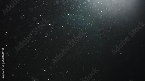Slow motion real dust particles floating mid air over dark background