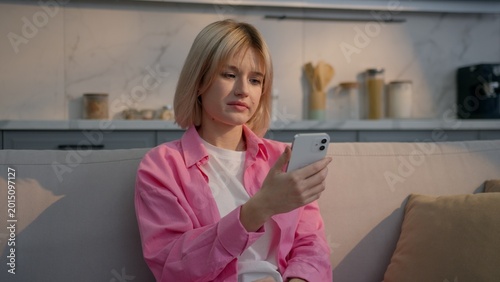 Φωτογραφία Upset Caucasian teenage girl woman at home browsing mobile phone receiving bad S