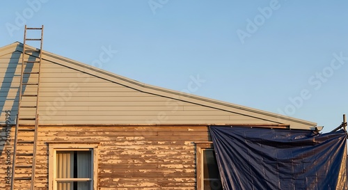 Foto Fixer upper house exterior showing old wood siding with peeling paint and a ladd