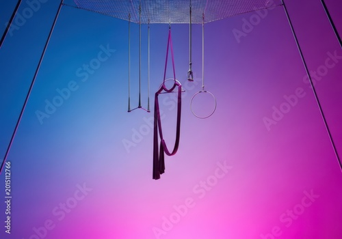 High-flying circus equipment suspended far above the safety net, ready for dramatic acrobatic stunts and thrilling aerial maneuvers during a performance, cable, gravity, high