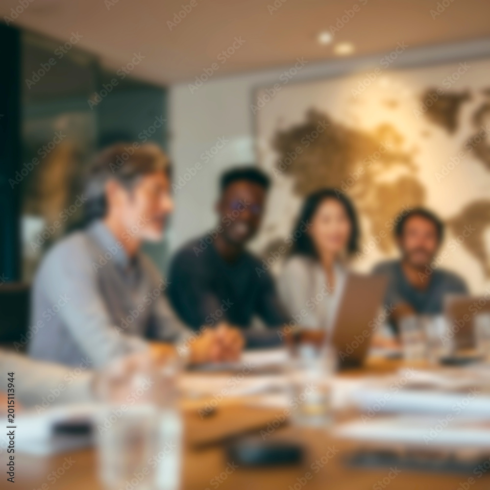 Fototapeta premium Blurred Diverse team collaborating in modern office space with laptops