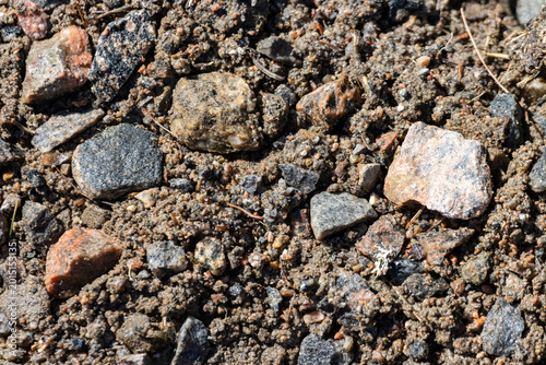 Tableau sur toile Quebec, Canada, 27 April 2026 : Close-up view of various small rocks and gravel mixed with brown soil on the ground