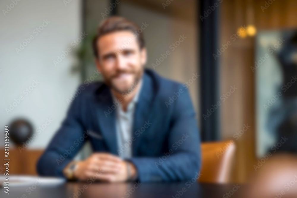 Fototapeta premium Blurred Confident businessman smiling in modern office setting