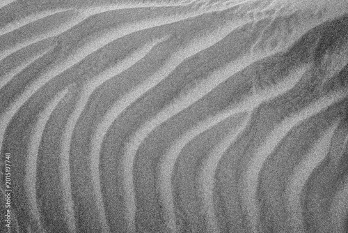 Konstfotografi Black and white close-up photograph of wind-shaped sand dunes with soft ripples and natural patterns