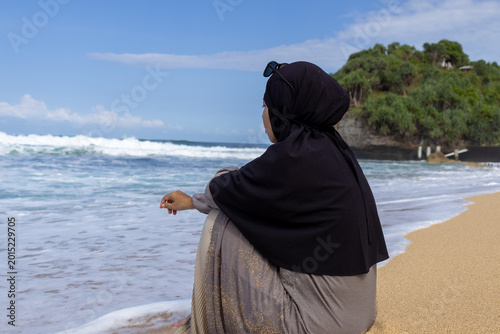 Fotografie Serene moment of a modest woman reflecting by the sea shore during summer vacation
